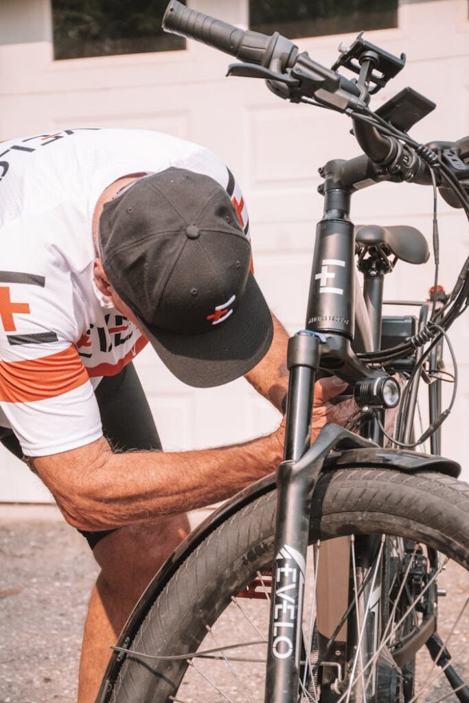 A man fixing his bike in front of a garage